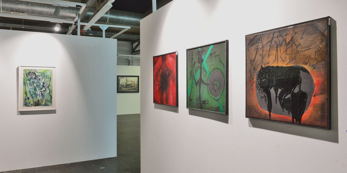 Eine Ausstellung mit weißen Wänden und 5 bunten Bildern.