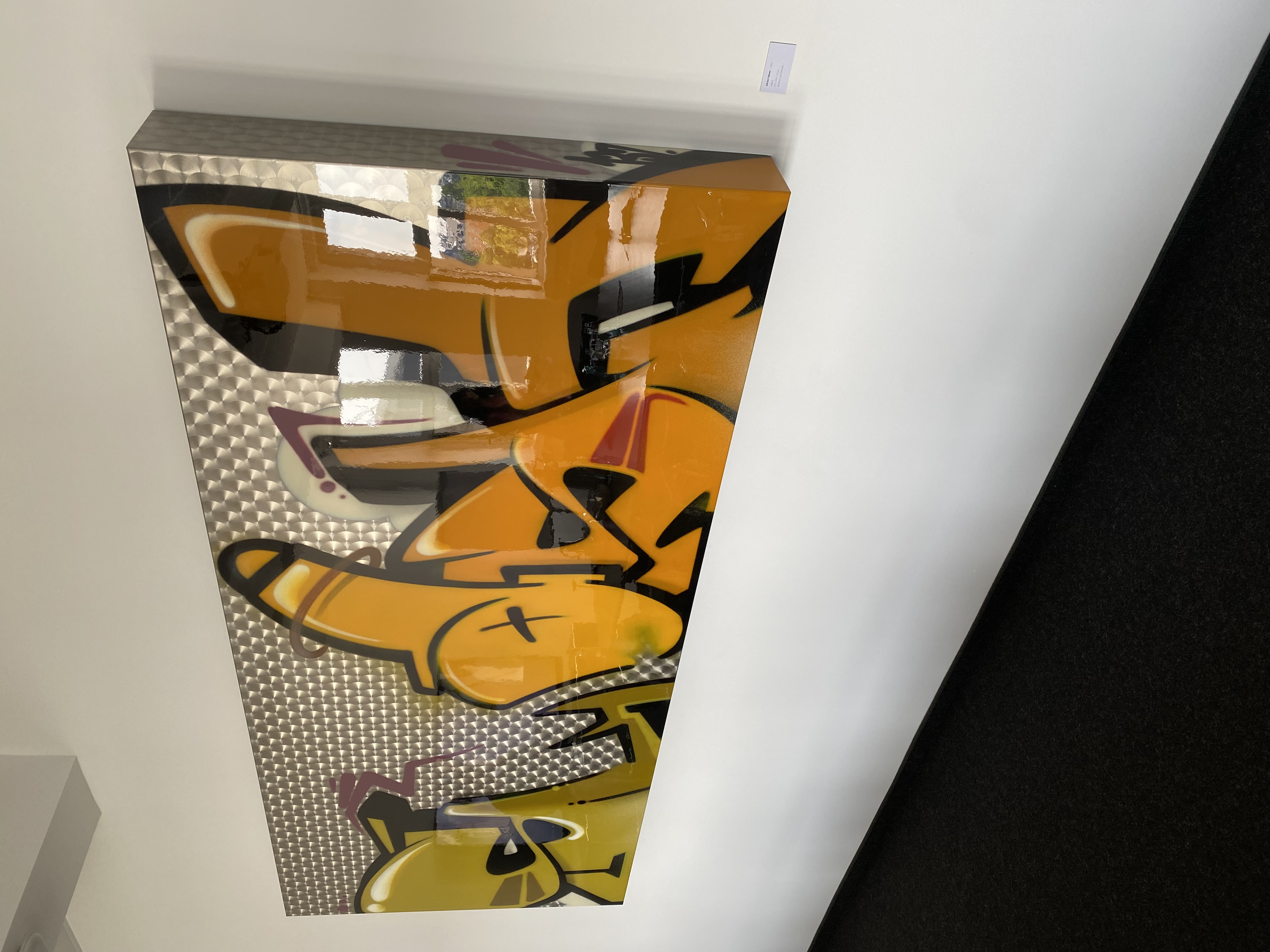 Eines gelbes Kunstwerk, das an Graffiti erinnert.